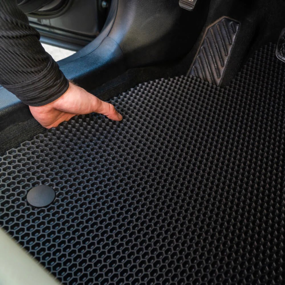 Schwarzer Gummifußmatte mit rutschfester Oberfläche im Auto.