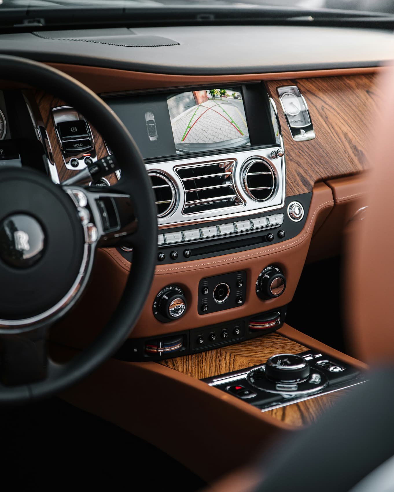 Luxuriöser Auto-Innenraum mit Holzarmaturenbrett und zentralem Touchscreen.
