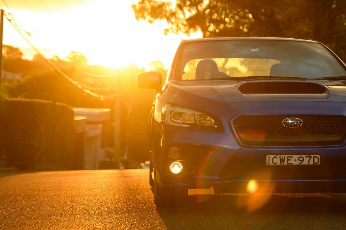 Auto Frontansicht auf Straße bei Sonnenuntergang im warmen Licht.