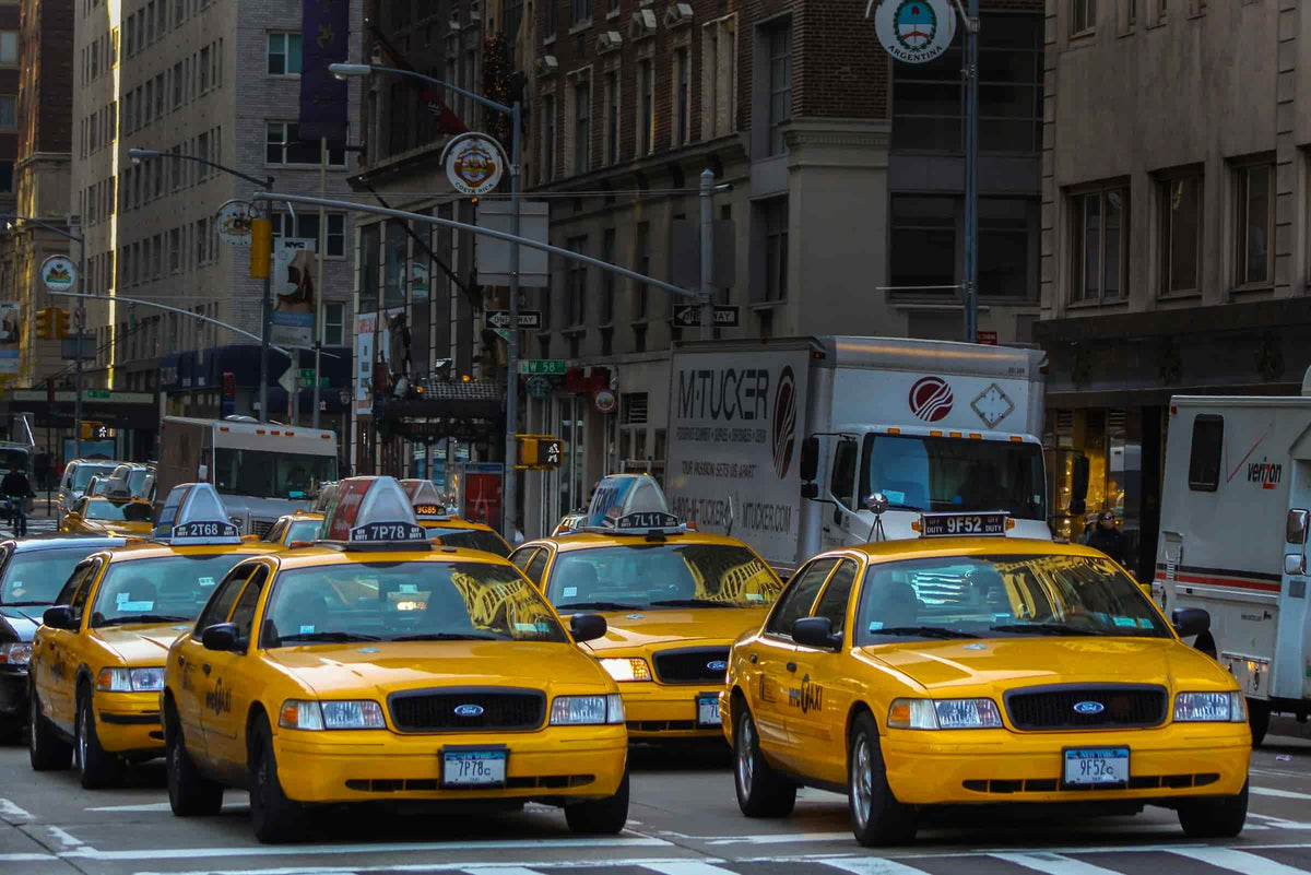 Gelbe Taxis fahren durch dichten Stadtverkehr.