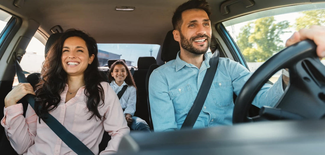 Eine glückliche Familie genießt eine Autofahrt und trägt Sicherheitsgurte.
