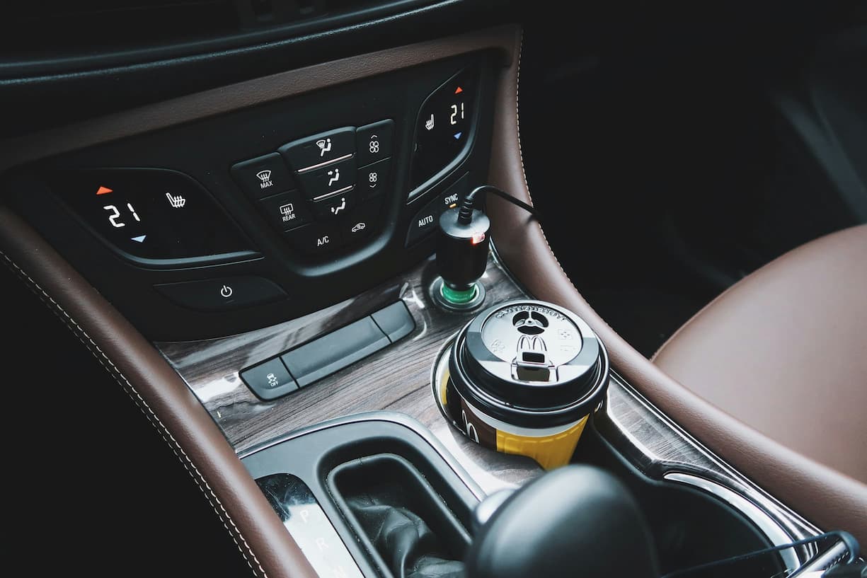 Autokonsole mit Getränkehalter und Klimabedienung.