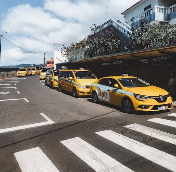Reihe von Taxis wartet auf Fahrgäste in einer Stadtstraße.