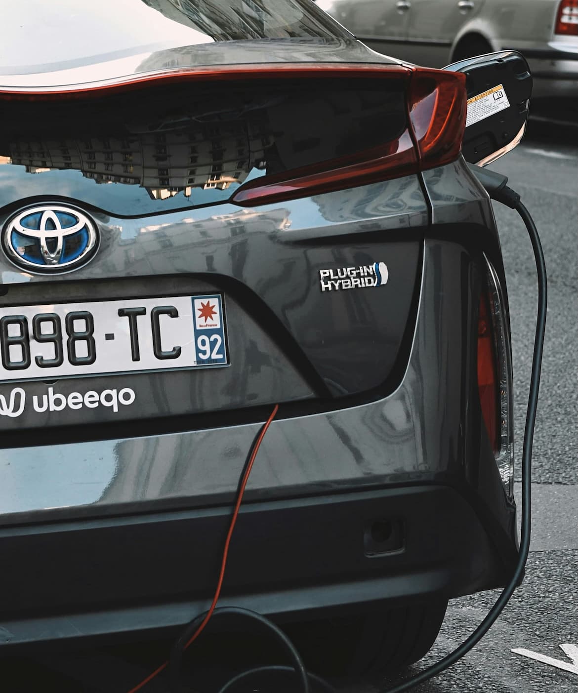 Toyota Plug-in-Hybrid beim Laden in der Stadt zeigt umweltfreundliche Mobilität.