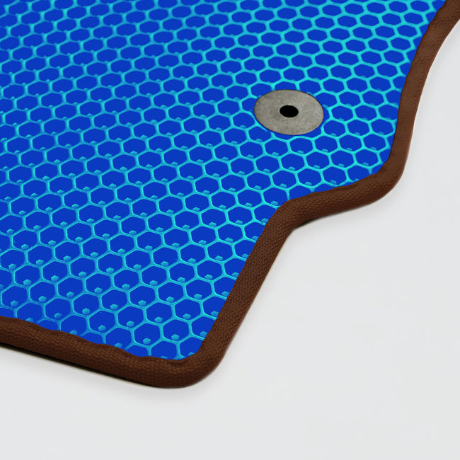 Blaue Matte mit Wabenmuster und braunem Rand, metallischer Knopf in der Mitte.
