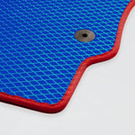 Blaues Gittermuster mit rotem Rand und Befestigungsloch auf einer Matte.