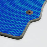 Blaues Mattenmaterial mit rautenförmigem Muster und einem Metallknopf.