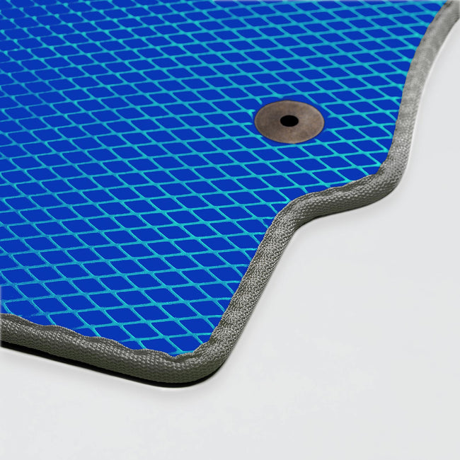 Blaues Mattenmaterial mit rautenförmigem Muster und einem Metallknopf.