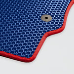 Blauer Teppich mit rotem Rand und Loch in der Ecke.