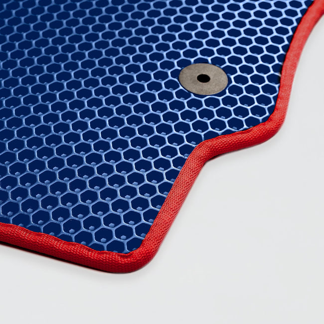 Blauer Teppich mit rotem Rand und Loch in der Ecke.