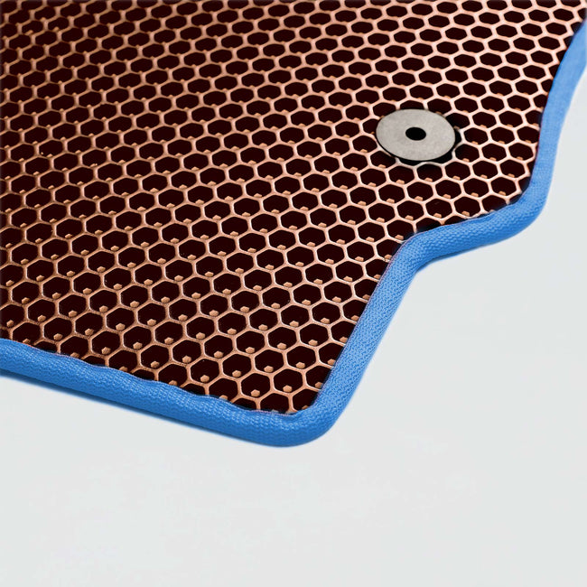 Ein kupferfarbener Teigmatte mit blauer Kante und Metallknopf.