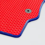 Rote Matte mit Wabenstruktur und blauer Umrandung, runder grauer Druckknopf